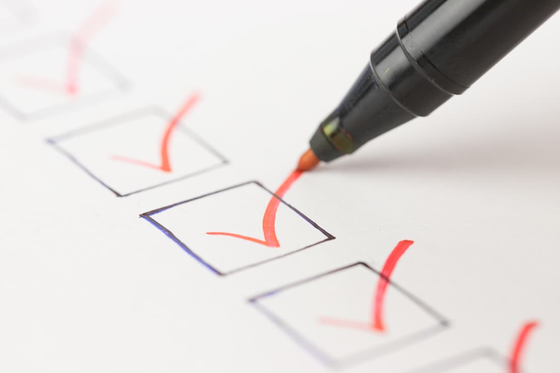 Vote pen on paper checking boxes.