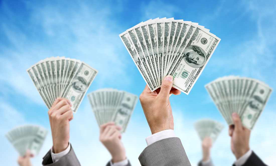several people holding up cash