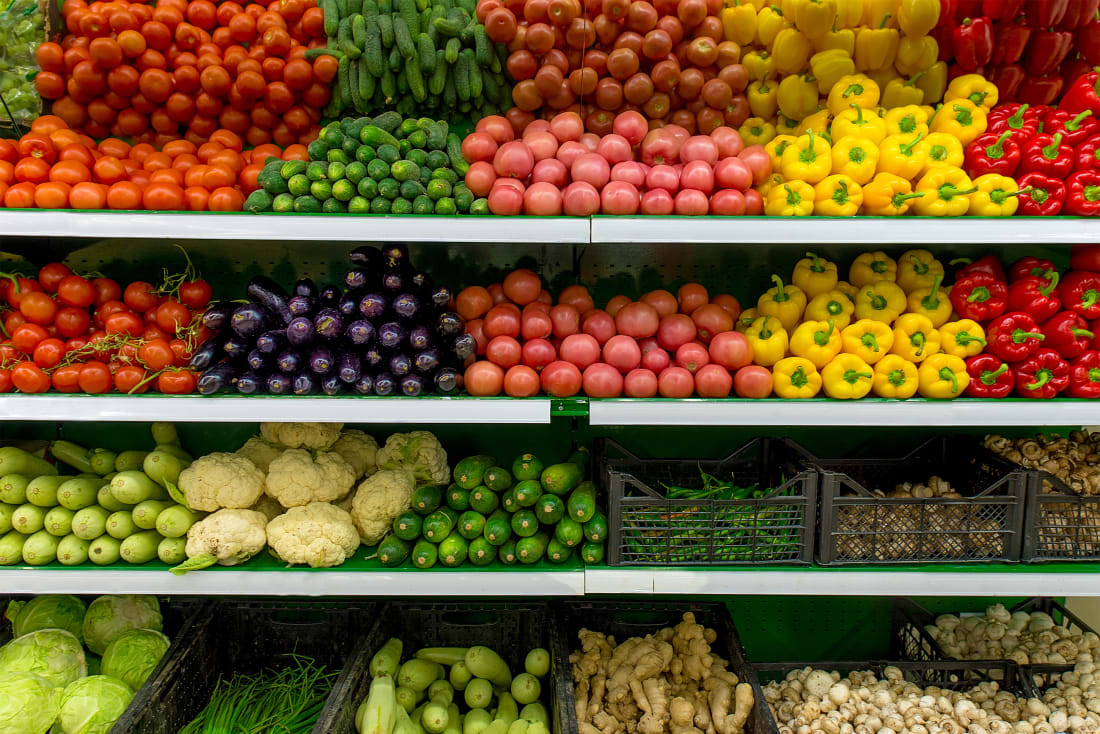 grocery shelves stocked with fruits and veggies