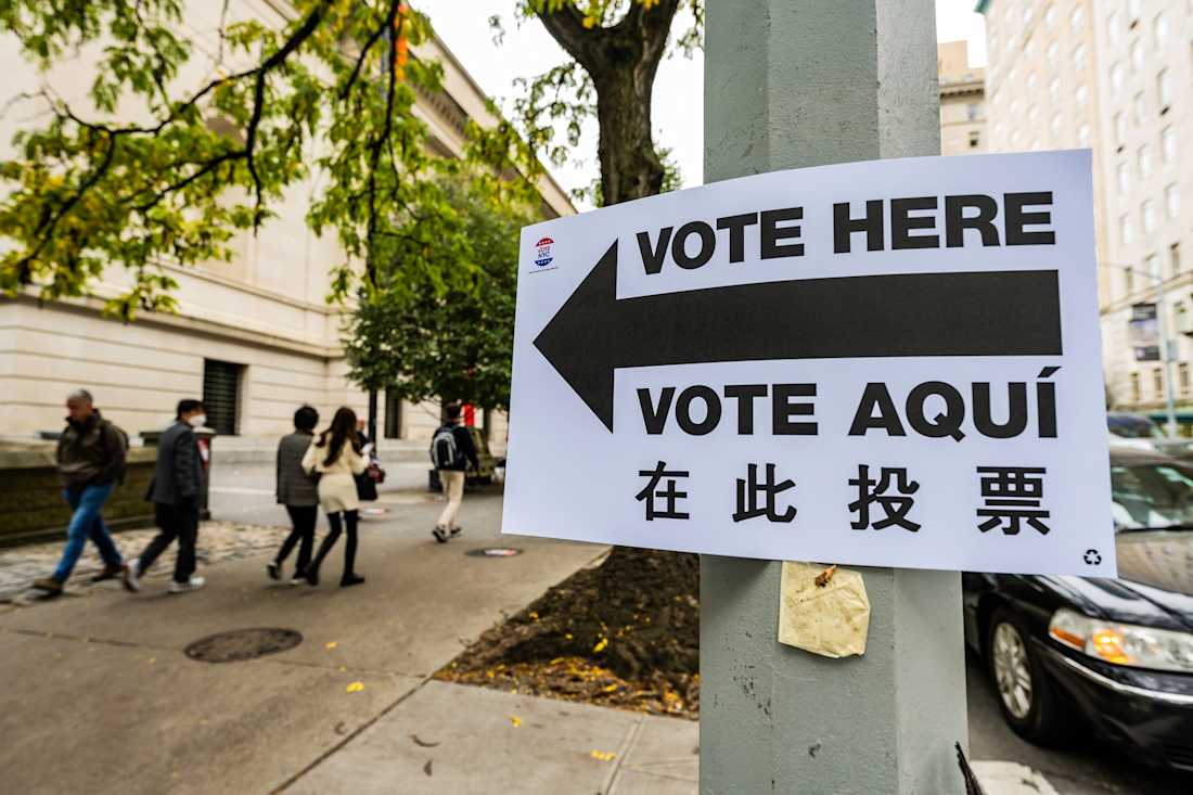Vote Here sign hanging on street post