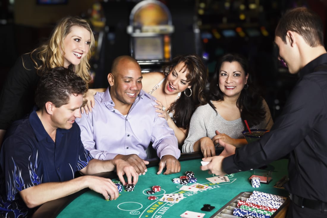 Diverse group of people playing Blackjack inside a casino