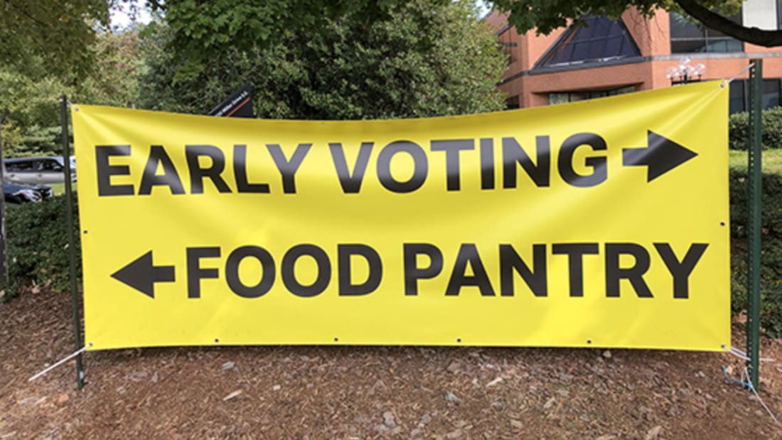 Signage showing that early voting is to the right and food pantry is to the left