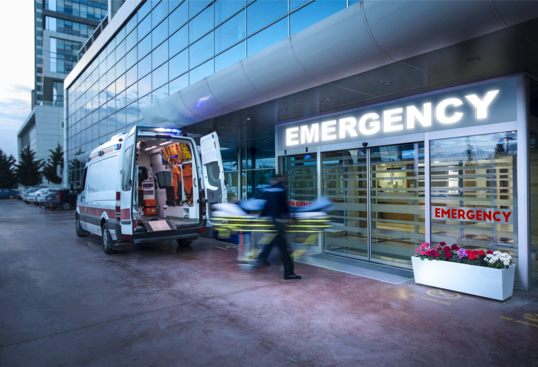 EMTs move patient from ambulance into hospital emergency room