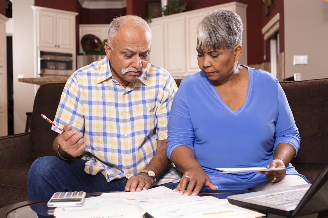 senior couple paying monthly bills at home