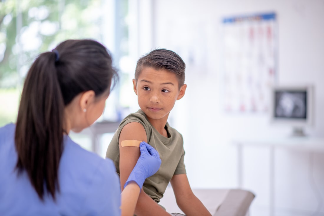 young boy getting vaccine from doctor