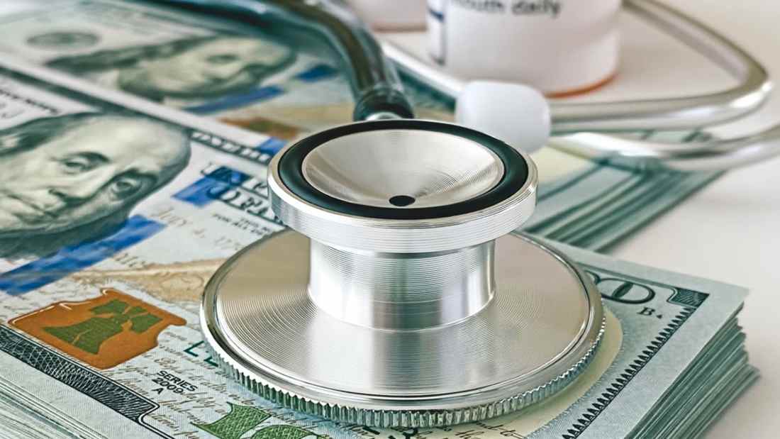 stethoscope on top of pile of money