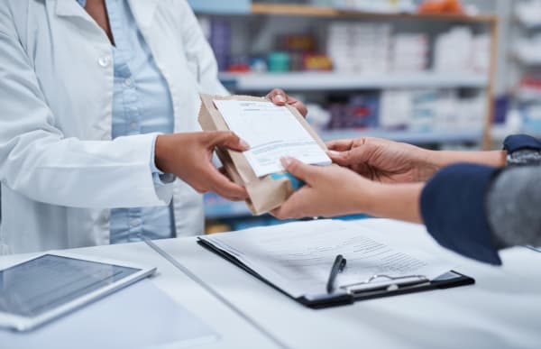 person picking insulin prescription up from a pharmacy