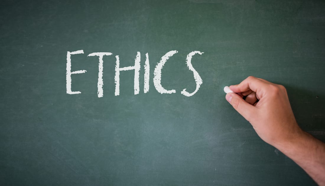 Word 'ethics' being written on chalkboard