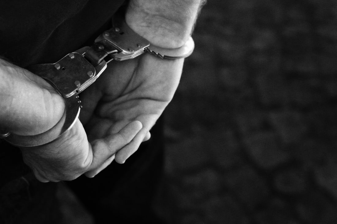 Man's hands handcuffed behind his back