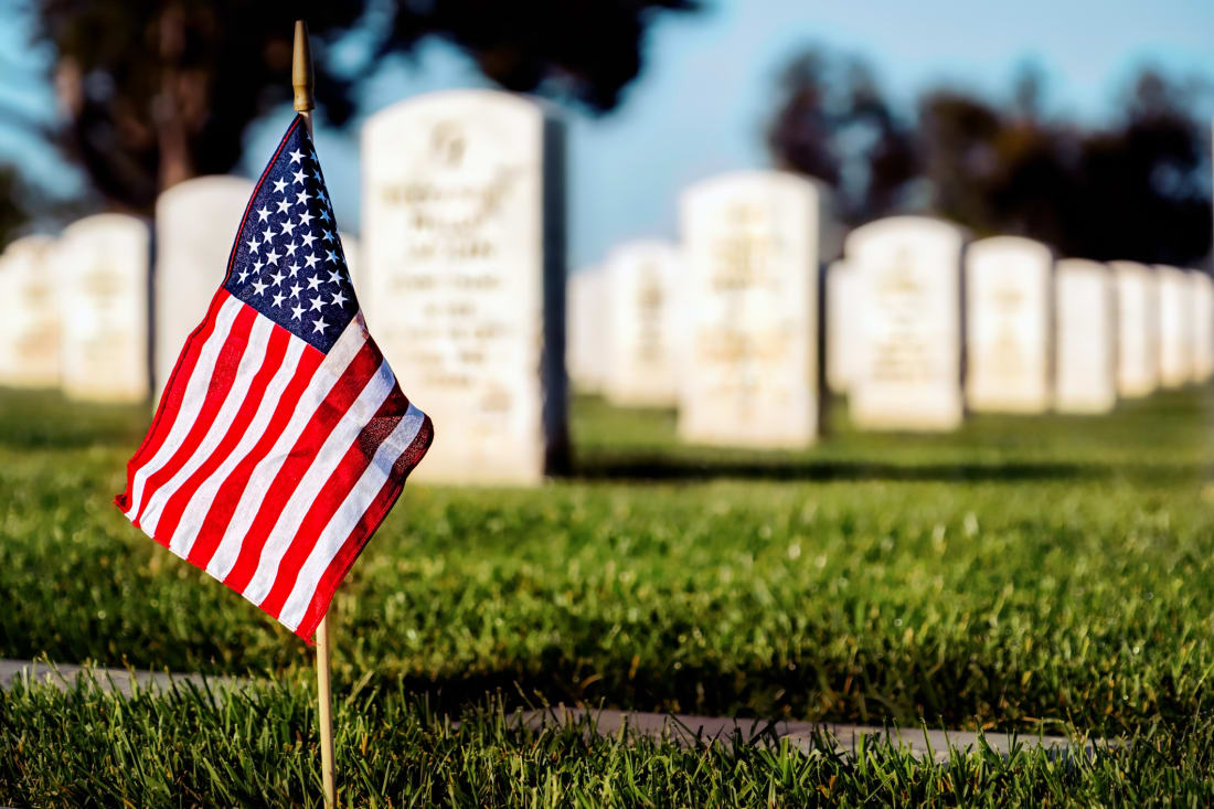A flag on a military grave at a cemetery