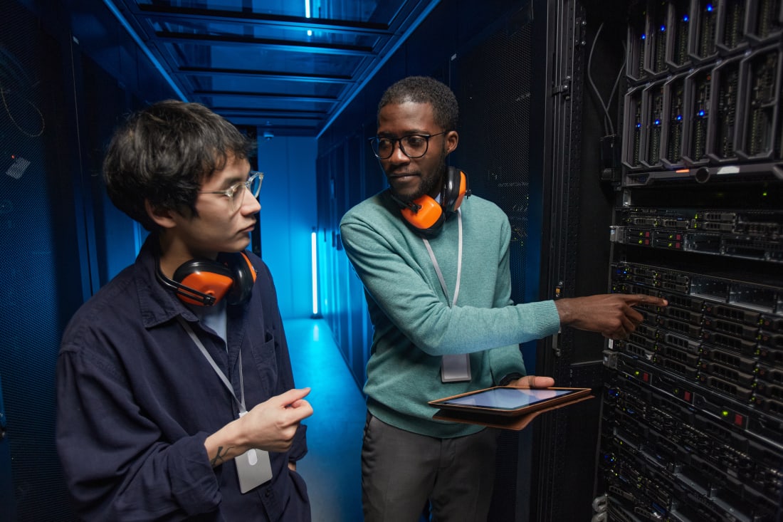 wo young technicians setting up server network while working in data center