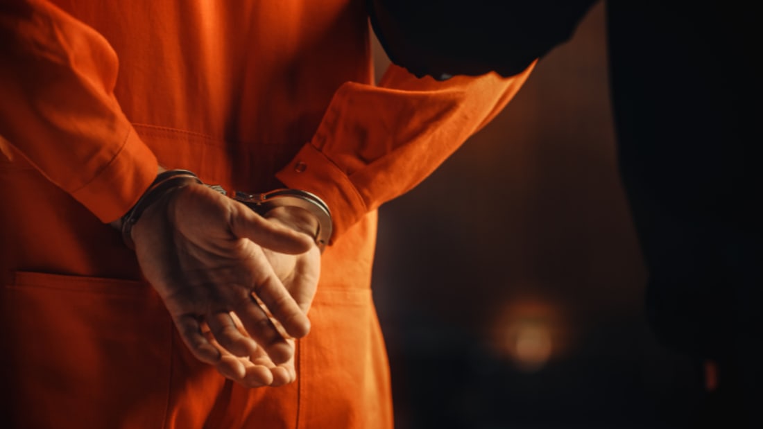 closeup of inmate in handcuffs from the rear