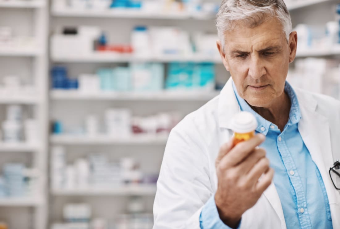 Pharmacist reading the label on a product in a drugstore