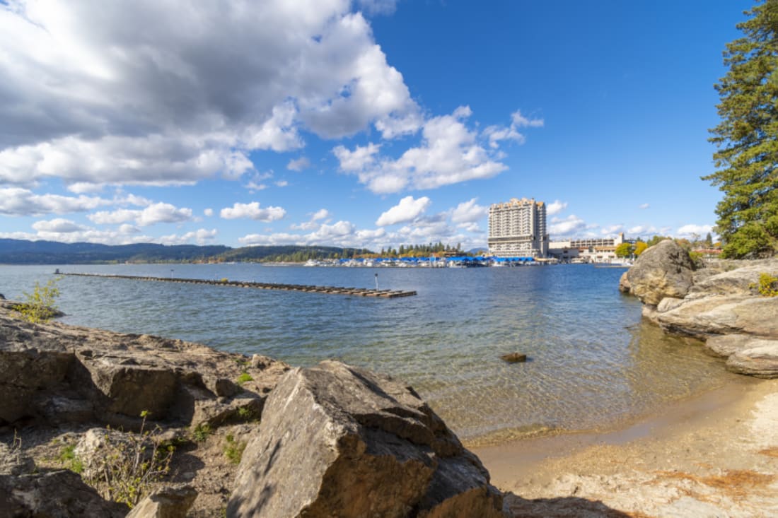 View from a small lakeshore beach on Tubbs Hill of the resort, lake, marina and boardwalk at Coeur d'Alene, Idaho 