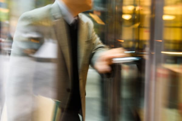 Businessperson walking through the revolving door in motion blur