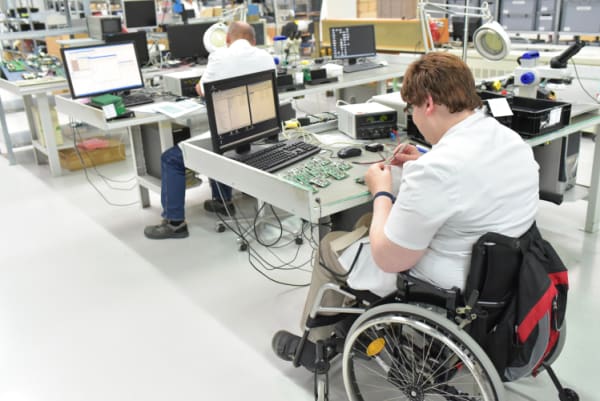 Worker in a wheelchair at a electronics manufacturing facility