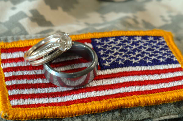 Wedding rings on top of US military flag on an Army uniform