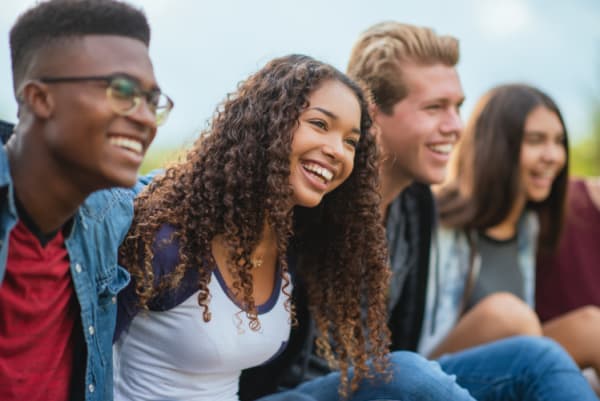 Group of diverse teenagers hanging out outdoors