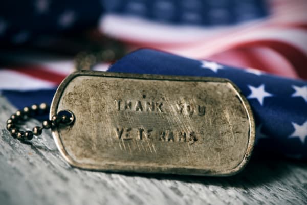 Rusty dog tag with the text 'thank you veterans' engraved in it