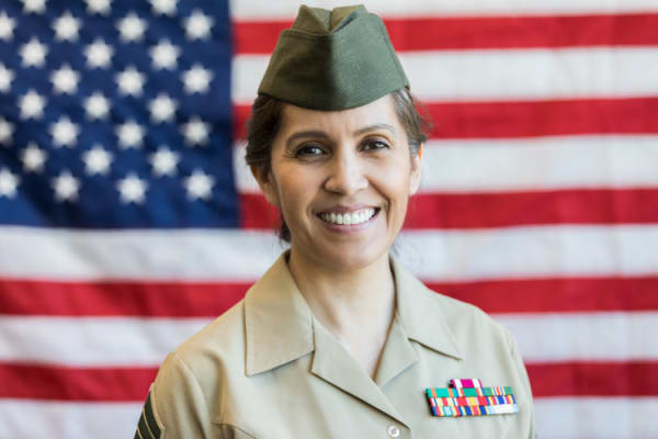 Mature Hispanic female military officer in front of American flag
