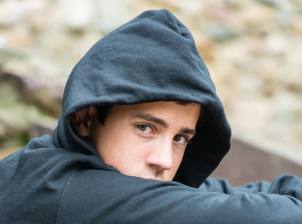 Pensive teenage boy wearing a hoodie 