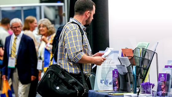 Man taking brochure from exhibit booth